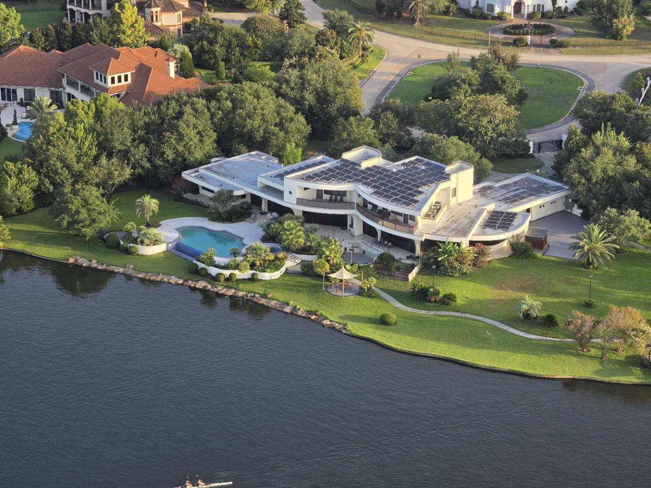 Aerial view of a modern waterfront estate in The Woodlands area