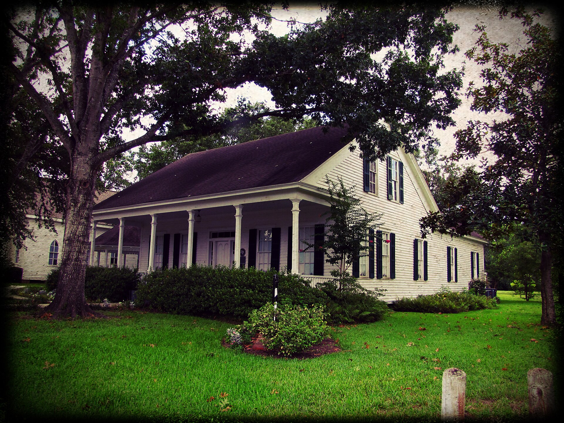 The historic Griffin House beneath mature trees in Tomball, Texas